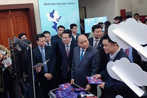 Prime Minister Nguyen Xuan Phuc, Head of the Central Propaganda Department of the Communist Party of Vietnam Vo Van Thuong, and Minister of Information and Communications Nguyen Manh Hung visited an exhibition booth on ICT achievements in the meeting