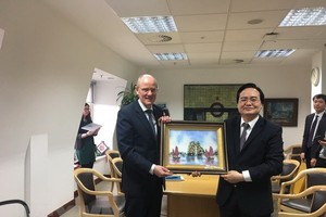 Vietnamese Minister of Education and Training Phung Xuan Nha (R) presents a gift to Minister of State at the UK Department for Education Nick Gibb (Photo: VNA)