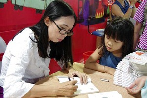 Author Vo Dieu Thanh in a book signing session in the Second Can Tho Book Fair. Photo by Van Thanh Le.