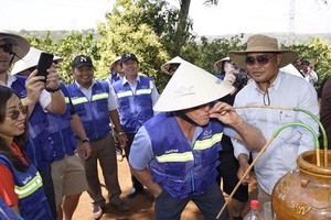 Vietnam's Tourism Ambassador Greg Norman tries ruou can (wine drunk from a jar through pipes) in the Central Highlands province of Dak Lak (Photo: vnexpress.net)
