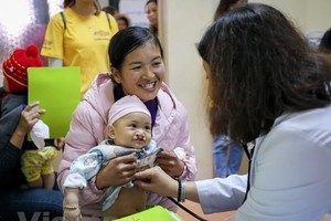A baby with cleft palates receives examination (Photo: VNA)
