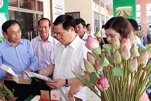 Deputy PM Vuong Dinh Hue sees produce  at the meeting (Photo: SGGP) 