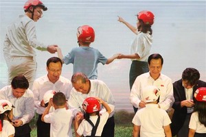 Deputy Prime Minister Truong Hoa Binh (third from left) presents a helmet to a first grader on June 12 (Photo: VNA)