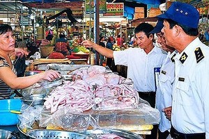 Inspectors visit a food booth in a tradiational market (Photo: SGGP)