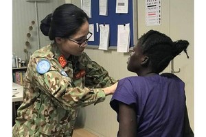 A Vietnamese doctor examines the governor's wife (Photo: SGGP)