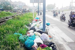People throw away garbage in Pham Van Dong Street (PHoto: SGGP)