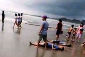 Four killed when big waves sweep 11 people out to sea 