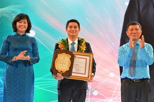 Deputy Editor-in Chief of Sai Gon Giai Phong Newspaper Ly Viet Trung gives prizes to a winner at the ceremony. (Photo: SGGP)
