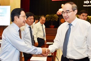 Secretary of HCMC Party Committee Nguyen Thien Nhan (R) shakes hands with delegates at the meeting (Photo: SGGP)