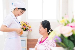 A nurse is guiding a mum a correct breastfeeding position (Photo: SGGP)