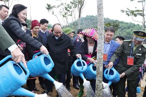 Prime Minister Nguyen Xuan Phuc (second from left) waters a tree after growing it as part of a tree-planting campaign launched in northern Yen Bai Province on Thursday (Photo: VNA)