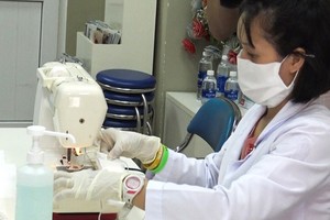 A medical worker of Tu Du Maternity Hospital’s testing faculty make cloth face masks (Photo: SGGP)