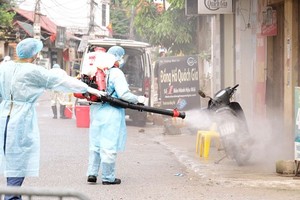 Medical workers spray disinfectant to clean the village (Photo: SGGP)