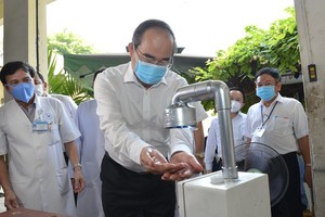 Secretary of the Ho Chi Minh City Party Committee Nguyen Thien Nhan washes his hand at automatic hand sanitizer dispenser at Thong Nhat Hospital (Photo: SGGP)