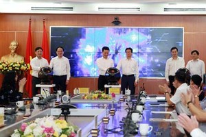 Deputy PM Vu Duc Dam, Minister of Information and Communications Nguyen Manh Hung, and other delegates press the button to officially launch Vpostcode platform. (Photo: VNP)