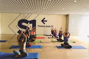 Staff of the VTC Television practise yoga during a break. (Photo: VNA)