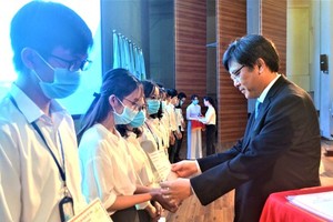 Deputy Director of the National University of Ho Chi Minh City Nguyen Minh Tam awards scholarships to students with financial difficulties and good performance (Photo: SGGP)