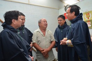 Secretary of Ho Chi Minh City Party Committee Nguyen Van Nen (R) and Chairman of HCMC People's Committee Nguyen Thanh Phong (L) visit people in flood hit areas in Thu Duc District (Photo: SGGP)