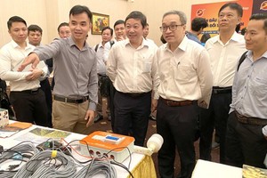 Deputy Minister of Information and Communications Phan Tam, Vice Chairman of HCMC People’s Committee Duong Anh Duc, and other delegates are visiting the ICT product exhibition