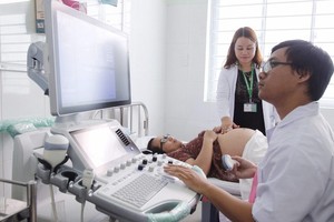 A doctor is examining a pregnant woman (Photo: SGGP)