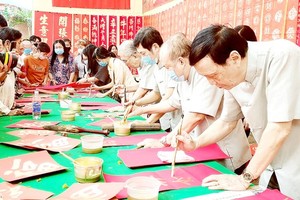 Calligraphers are using brushes to make beautiful writings (Photo: SGGP)