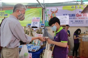 A customer buys banh chung at a fair in HCM City. (Photo: nld.com.vn)