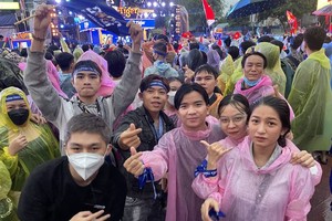 Despite rain, fans in high spirit in street watching football match