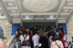 People in HCMC wait in long queues at passport office on July 1