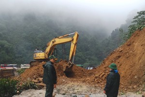 Local forces try to clear landslide debris on National Highway 8A
