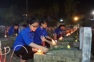 Students light up candles at the Vietnam-Laos martyr cemetery in the central province of Nghe An to remember more than 11,000 Vietnamese volunteer soldiers who laid down their lives in Laos during wartime. (Photo: dantri.vn)