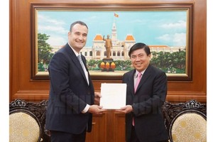 Ho Chi Minh City People’s Committee Chairman Nguyen Thanh Phong offers a souvenir to new Canadian Consul General  in Ho Chi Minh City Kyle Nunas (Photo: HCMC Gov)