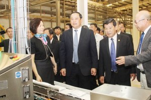 Lao Deputy Prime Minister Sonexay Siphandone visits a factory of Vietnam Dairy Products Joint - Stock Company