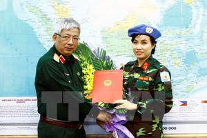 Deputy Minister of National Defence Senior Lieutenant General Nguyen Chi Vinh (L) hands over to Major Do Thi Hang Nga a decision sending her to UN peacekeeping mission in South Sudan (Photo: VNA)