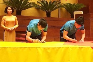 Vietnamese U23 footballers respectively sign names on national flag 