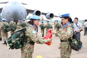 Two members of the level-2 field hospital folded the military flag before the departure of the peacekeeping force in October 2018. (Photo: VNA)
