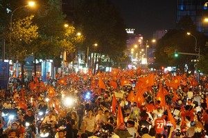 Football fans with national flags, trumpets and drums flock to streets cheering the victory
