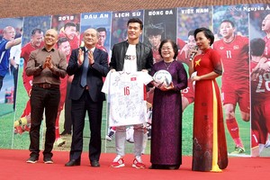 Former Vice President of Vietnam and Chairman of Vu A Dinh Scholarship Fund Truong My Hoa receives the jerseys and ball from representatives of the football team(Photo:Huy Dung)