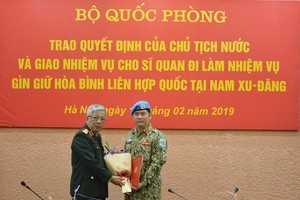 Deputy Minister of National Defence Sen. Lieut. Gen. Nguyen Chi Vinh (left) hands over the President’s decision to Lieut. Colonel Nguyen Kim Tinh. (Source: qdnd.vn)