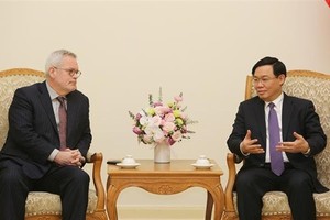 Deputy Prime Minister Vuong Dinh Hue (R) receives Charles Freeman, Senior Vice President for Asia at the US Chamber of Commerce, in Hanoi on March 8 (Photo: VNA)