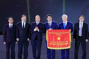 Prime Minister Nguyen Xuan Phuc (third from left) presents the Government’s Emulation Flag to the Vietnam National Cement Corporation. 