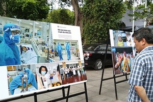 A visitor looks at Nguyen A's photo collection depicting the work of doctors at the National Hospital of Tropical Diseases. — VNS Photo Minh Thu