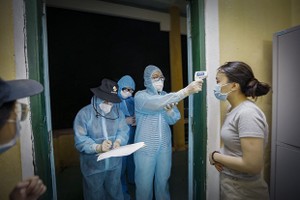 Health workers record health information of a woman at a quarantine site (Photo: VNA)