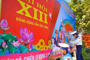 Naval soldiers hang on a poster to welcome the 13th National Party Congress (Photo: VNA)