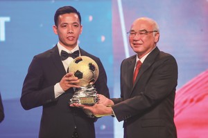 Head of the Propaganda and Training Board Mr. Phan Nguyen Nhu Khue hands over golden ball to football player Nguyen Van Quyet