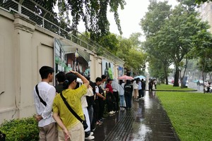 People queue in rain to get into French Residence in Ho Chi Minh City