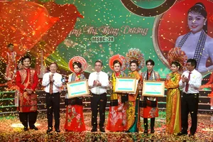 Phó Bí thư Thành ủy, Chủ tịch UBMTTQ Việt Nam TPHCM Nguyễn Phước Lộc, Trưởng Ban Tuyên giáo và Dân vận Thành ủy TPHCM Dương Anh Đức và Tổng Giám đốc Đài Truyền hình TPHCM Cao Anh Minh, trao giải thưởng Chuông Vàng cho thí sinh Đặng Thị Thùy Dương và cùng chụp hình với các nghệ sĩ trong ban huấn luyện. Ảnh: THÚY BÌNH