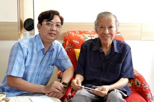 Nhạc sĩ Nguyễn Quang Vinh, Chủ tịch Hội Âm nhạc TPHCM đến thăm và tặng quà mừng tuổi nhạc sĩ Trần Long Ẩn, người Thầy đáng kính của anh. Ảnh: THÚY BÌNH