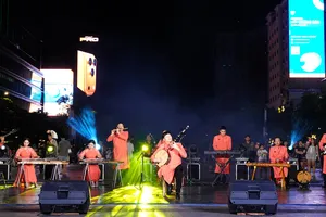 NSƯT Anh Tấn biểu diễn cùng dàn nhạc dân tộc Nhà hát Ca múa nhạc dân tộc Bông Sen trong tiết mục độc tấu đàn kìm "Ngẫu hứng sen". Ảnh: THÚY BÌNH