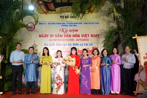 Lãnh đạo phường Tân Định tặng hoa chúc mừng Ban Chủ nhiệm CLB Đờn ca tài tử phường Tân Định. Ảnh: THÚY BÌNH