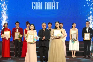 Chủ tịch Hội Nhạc sĩ Việt Nam, Thiếu tướng - nhạc sĩ Nguyễn Đức Trịnh trao giải nhất cho thí sinh Bùi Huyền Trang (Học viện Âm nhạc Quốc gia Việt Nam) và Trần Nguyễn Kim Ngân (Nhạc viện TPHCM). Ảnh: THÚY BÌNH 